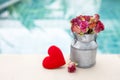 Paper rose flower in metal can and red heart over blurred blue water, Royalty Free Stock Photo