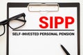 Paper with Self-Invested Personal Pension SIPP on a table