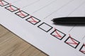 Paper sheet with checkboxes and pen on wooden table, closeup. Checklist Royalty Free Stock Photo