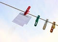 Paper sheet notepad hanging on a rope on clothespins on a light blue background. Royalty Free Stock Photo