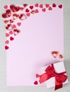 Paper sheet surrounded by handmade paper hearts and gift box Royalty Free Stock Photo