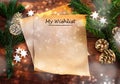 Paper sheet with text My Wishlist between fir branches, cinnamon stars and Christmas decoration on rustic dark wood, wish list or Royalty Free Stock Photo