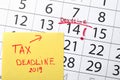 Paper sheet with text TAX DEADLINE on calendar with marked date