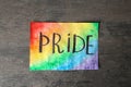 Paper sheet with word PRIDE on grey background. LGBT concept