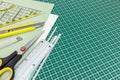 Paper sheets, yellow cutter, scissors and ruler on green cutting Royalty Free Stock Photo