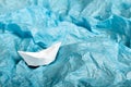 Paper ship in blue tissue paper