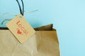 Paper shopping bag on a blue background. Label with heart and text LOCAL. Shopping concept