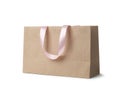 Paper shopping bag with ribbon handles on white background. Royalty Free Stock Photo