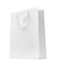 Paper shopping bag with ribbon handles on white background. Royalty Free Stock Photo