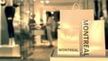 Paper shopping bags with Montreal caption against blurred store entrance. Retail in Canada related conceptual 3D