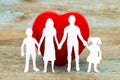 Paper silhouette of family and heart on wooden background. Health insurance concept Royalty Free Stock Photo