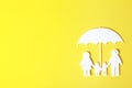 Paper silhouette of family under umbrella and space for text on color background, top view. Royalty Free Stock Photo