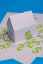 Paper skyscrapers , us dollar money, house projects plan and blueprints on blue background paper. Minimalistic and simple concept Royalty Free Stock Photo
