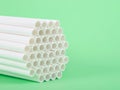 Paper straws clustered together on green background