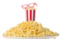 Paper striped bucket and 3D glasses on a heap of popcorn isolated on white Royalty Free Stock Photo