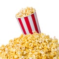 Paper striped bucket on a heap of popcorn isolated on white background Royalty Free Stock Photo