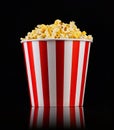 Paper striped bucket with popcorn on isolated black background Royalty Free Stock Photo
