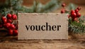 Paper tag with word voucher on christmas tree branch background Royalty Free Stock Photo