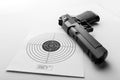 Paper target and pistol on white