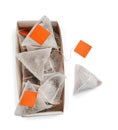 Paper tea bags with tags and box on white background, top view Royalty Free Stock Photo