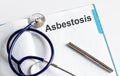 Paper with text ASBESTOSIS on table with stethoscope