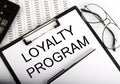 Paper with text Loyalty Program on the table on the chart
