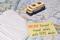 Paper with text `OMICRON Variant travel safely with FFP2 masks` above map of Europe with ffp2 type protection masks and a model Royalty Free Stock Photo
