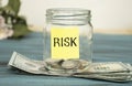 paper with the text RISK on a glass jar with