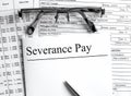 Paper with text Severance Pay on a financial table with eyeglasses and metal pen