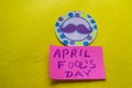 Paper topper with a painted mustache and the words April fool`s day, yellow background