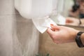 Paper towel dispenser. Hand of woman takes paper towel in bathroom Royalty Free Stock Photo