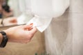 Paper towel dispenser. Hand of woman takes paper towel in bathroom. Royalty Free Stock Photo