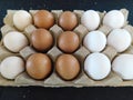 A paper tray of mixed fifteen white and brown eggs on display