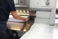 Paper trimming on a guillotine. Work in the printing house Royalty Free Stock Photo