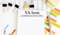 Paper with VA loan on a table with charts Royalty Free Stock Photo