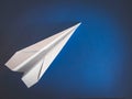 Paper white aircraft lying on a blue background