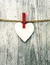 Paper white heart on a rope on grunge wooden background. Royalty Free Stock Photo