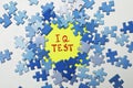 Paper with words IQ Test, puzzles on white table, flat lay