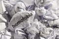 Paper written homofobia, portuguese and spanish word for homophobia. Concept of old and abandoned idea or practice.