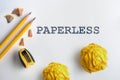 PAPERLESS text and Yellow pencil and a yellow crumpled paper wit