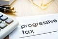 Papers about progressive tax on a desk. Royalty Free Stock Photo