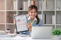 Paperwork. Happy smiling asian business woman in formal wear sitting at wooden desk in modern office and reading report Royalty Free Stock Photo