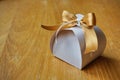 Papery gift box with a golden ribbon on the top