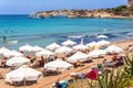 PAPHOS, CYPRUS - JULY 24, 2016: Tourists, sunbeds and umbrellas on hot summer day at Coral Bay Beach Royalty Free Stock Photo