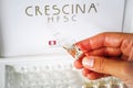 Woman hand with ampoule of Crescina HFSC Re-Growth formula