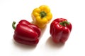 Yellow and two red bell peppers with green cuttings Royalty Free Stock Photo