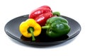 Bell pepers in a plate over white background. Sweet peppers in black dish isolated Royalty Free Stock Photo