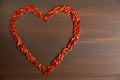 Paprika red pepper in the shape of heart. The texture on a wooden background. Valentine`s Day. Royalty Free Stock Photo