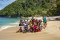 Indonesian funny children are photographed with tourists on the Pantai Base beach in Sentani