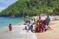 Indonesian funny children are photographed with tourists on the Pantai Base beach in Sentani, Jayapura